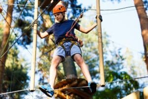 teenager taking part in an outdoor ropes course as part of 5 activities to improve your mental health